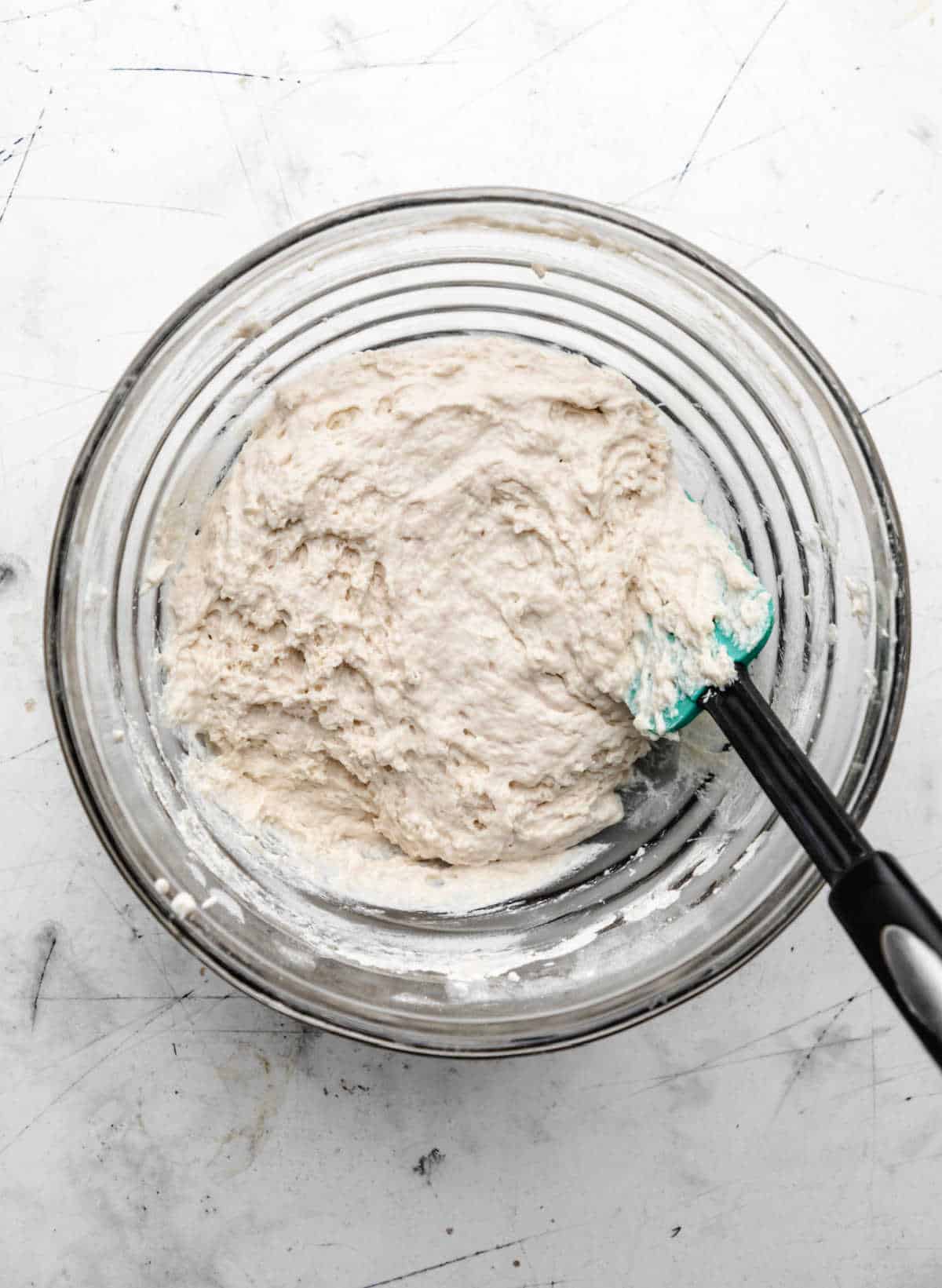 Buttermilk mixed into dry ingredients in a glass mixing bowl. 