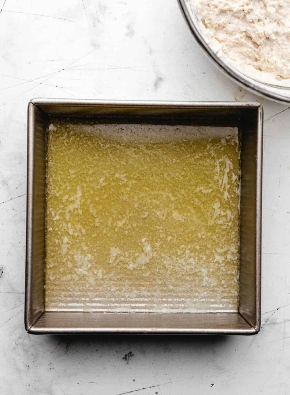 Melted butter in an 8 by 8 pan.