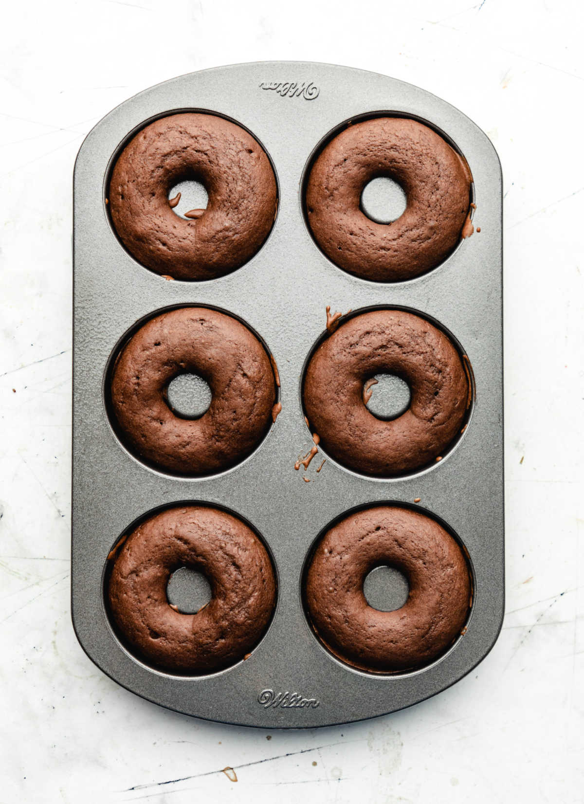 Baked chocolate buttermilk donuts in a donut pan.