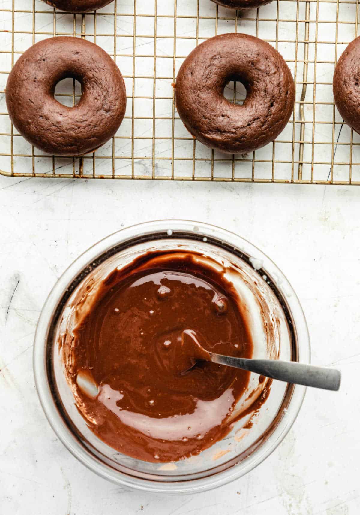 Chocolate buttermilk glaze next to a wire cooling rack.
