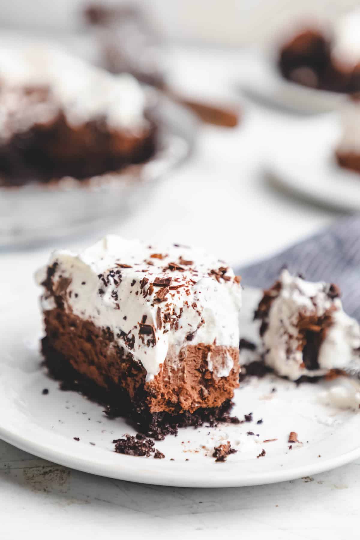 A slice of chocolate mousse pie with a bite on a fork next to it. 