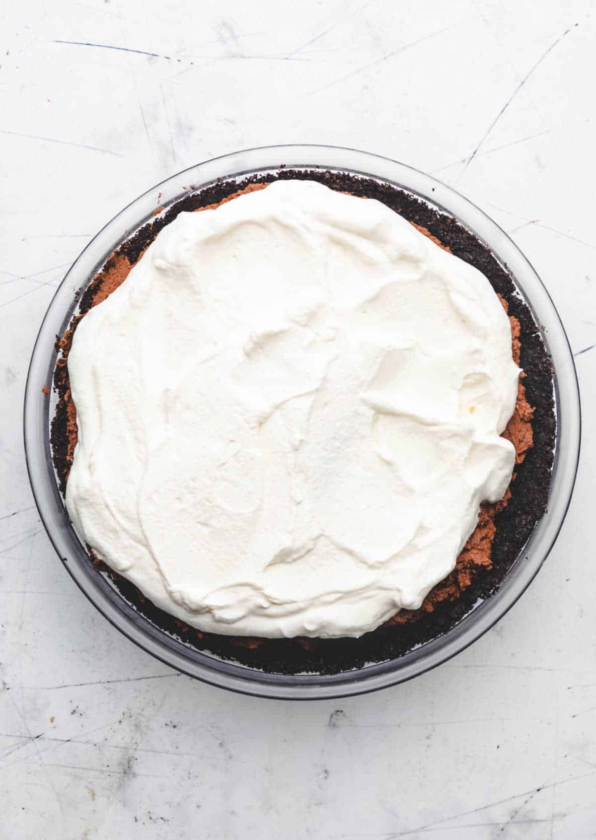 Whipped cream spread over chocolate mousse in an Oreo crust. 