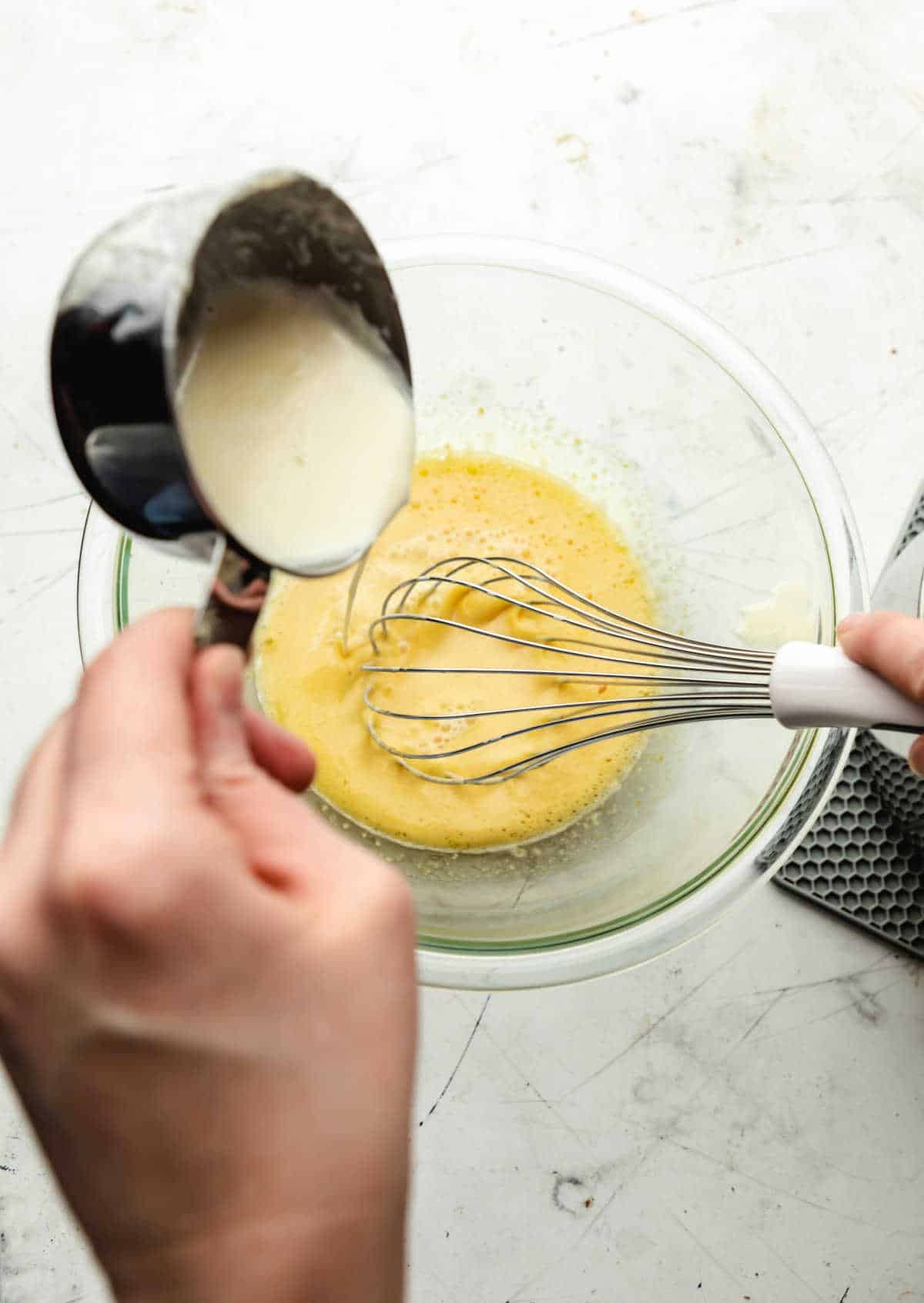 Hot cream streaming into egg mixture. 