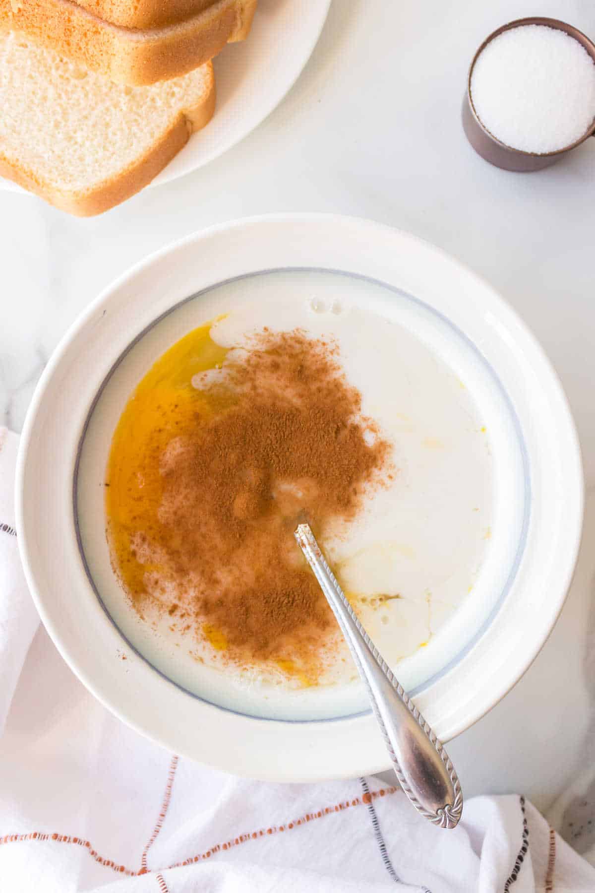 Milk, cinnamon, eggs, and vanilla in a shallow dish. 