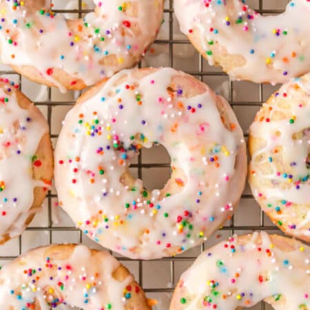 Baked funfetti donuts on a wire cooling rack.