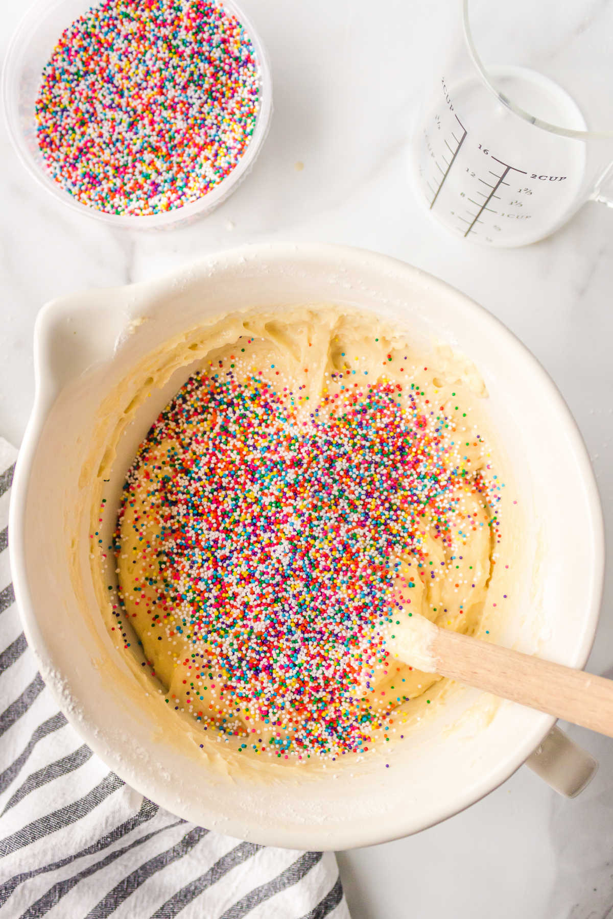 Sprinkles on top of batter in a mixing bowl. 