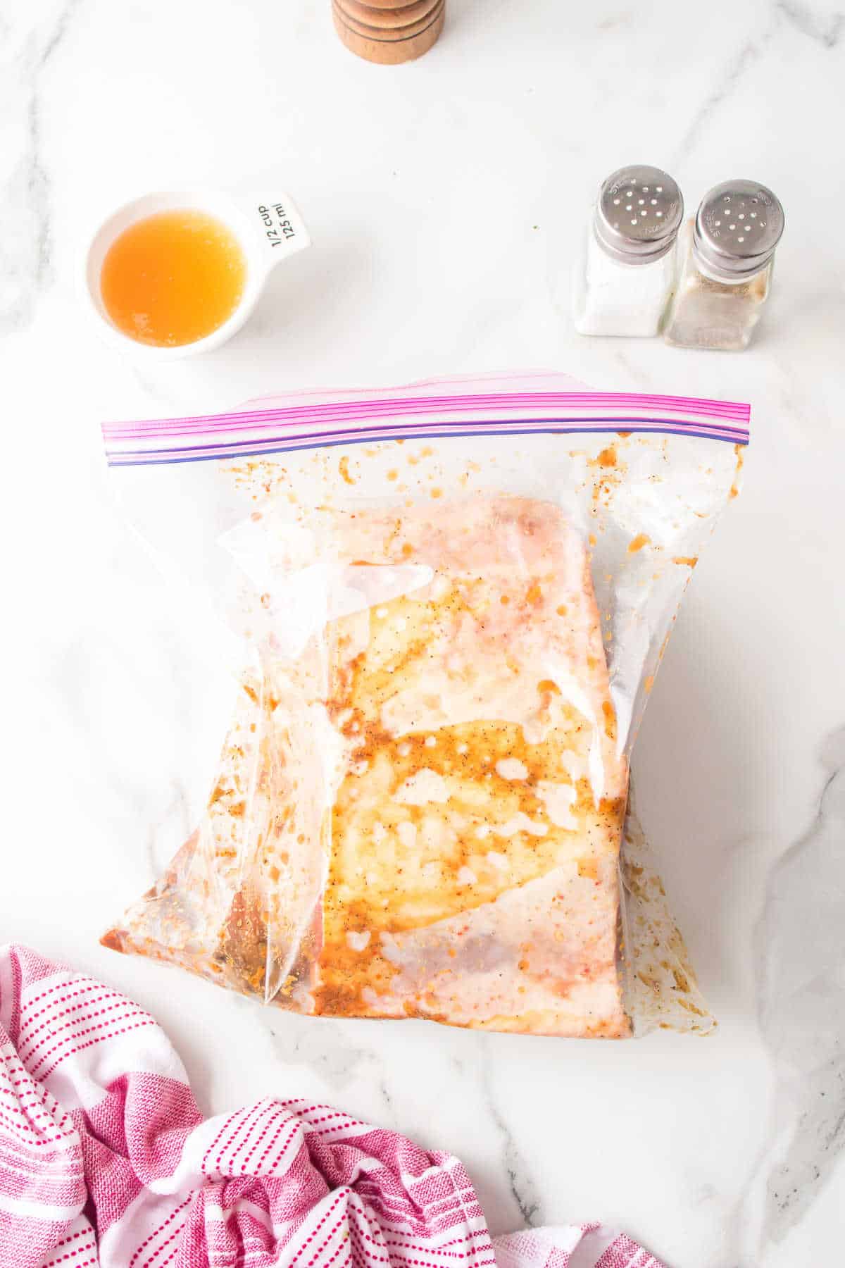 A brisket in a plastic bag in marinade. 