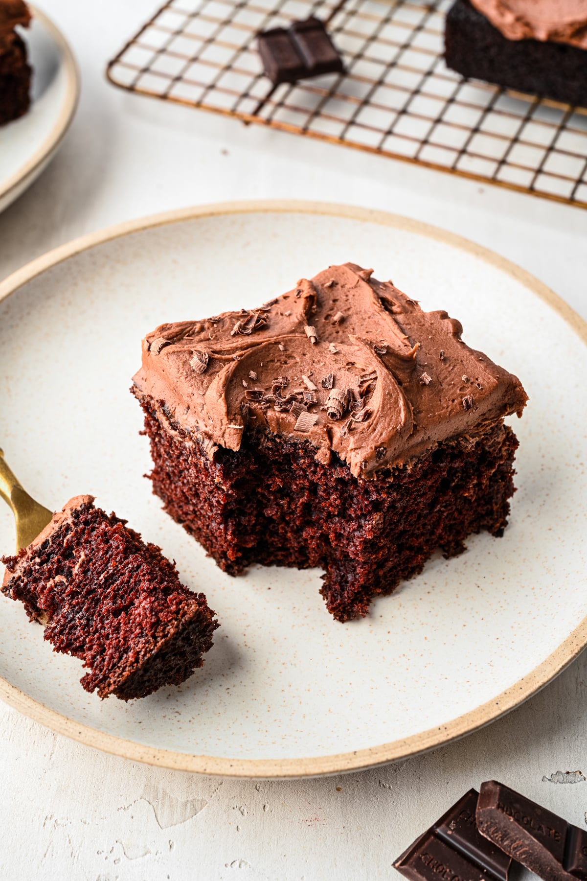 A slice of chocolate wacky cake with a bite on a fork. 