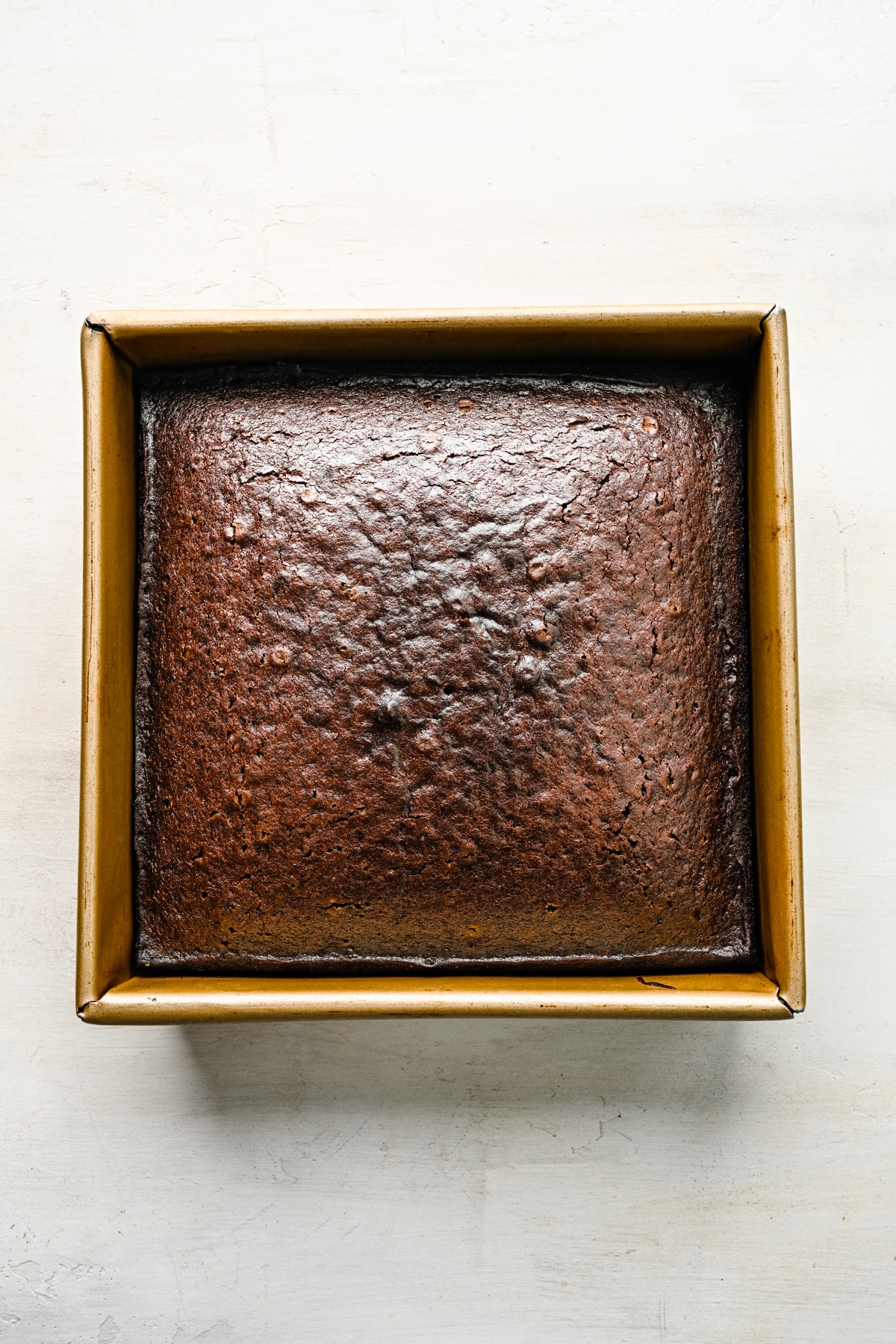 Baked wacky cake in a square metal baking pan. 