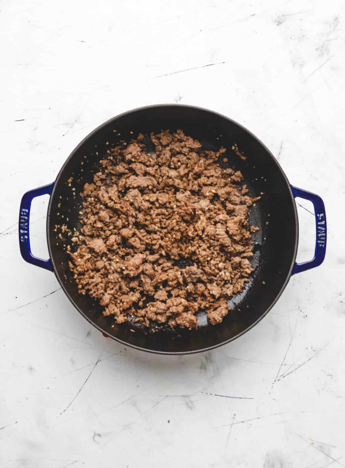 Browned Italian sausage  and garlic in a pan. 