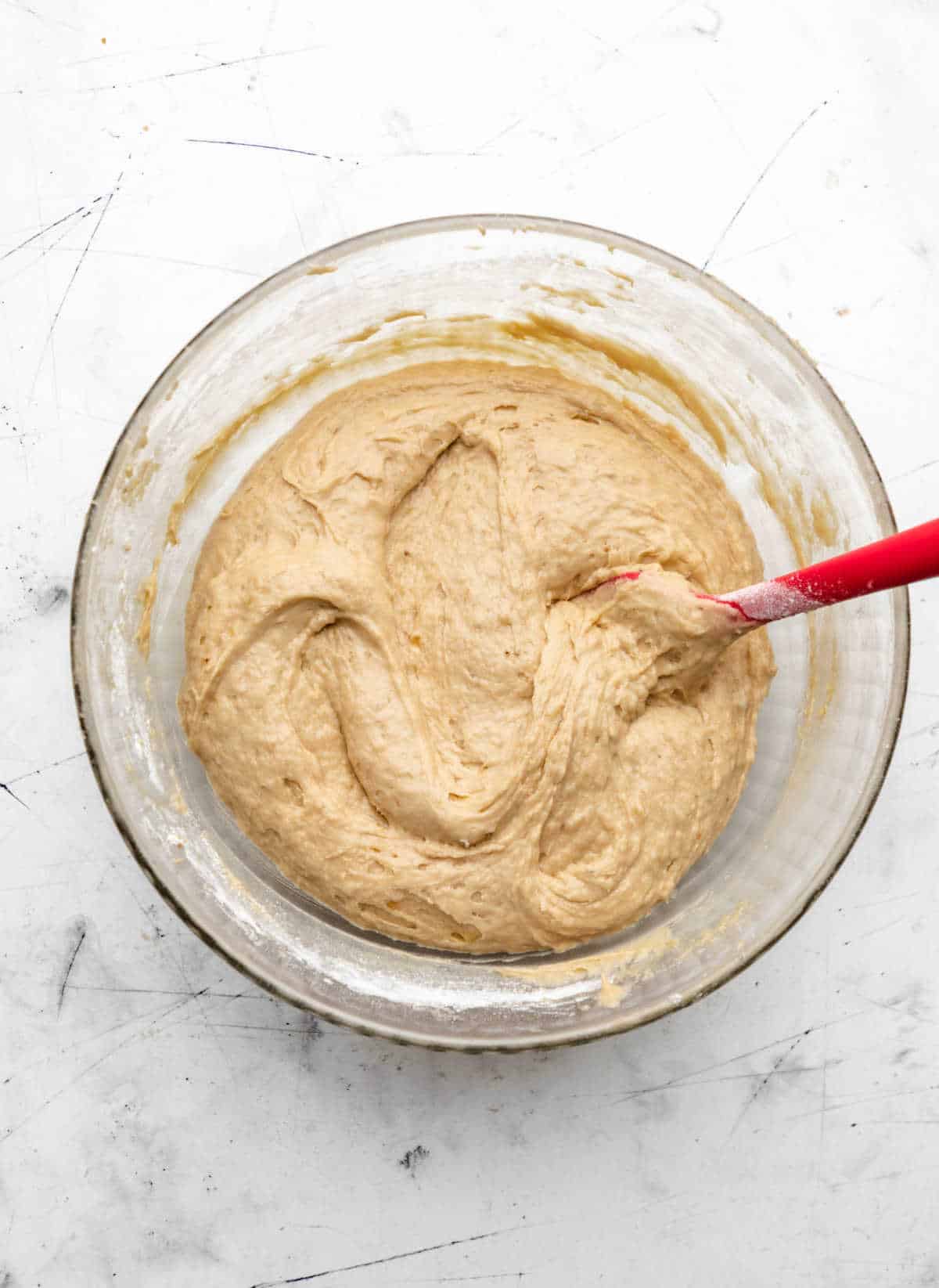 Banana crumb cake batter in a glass mixing bowl. 