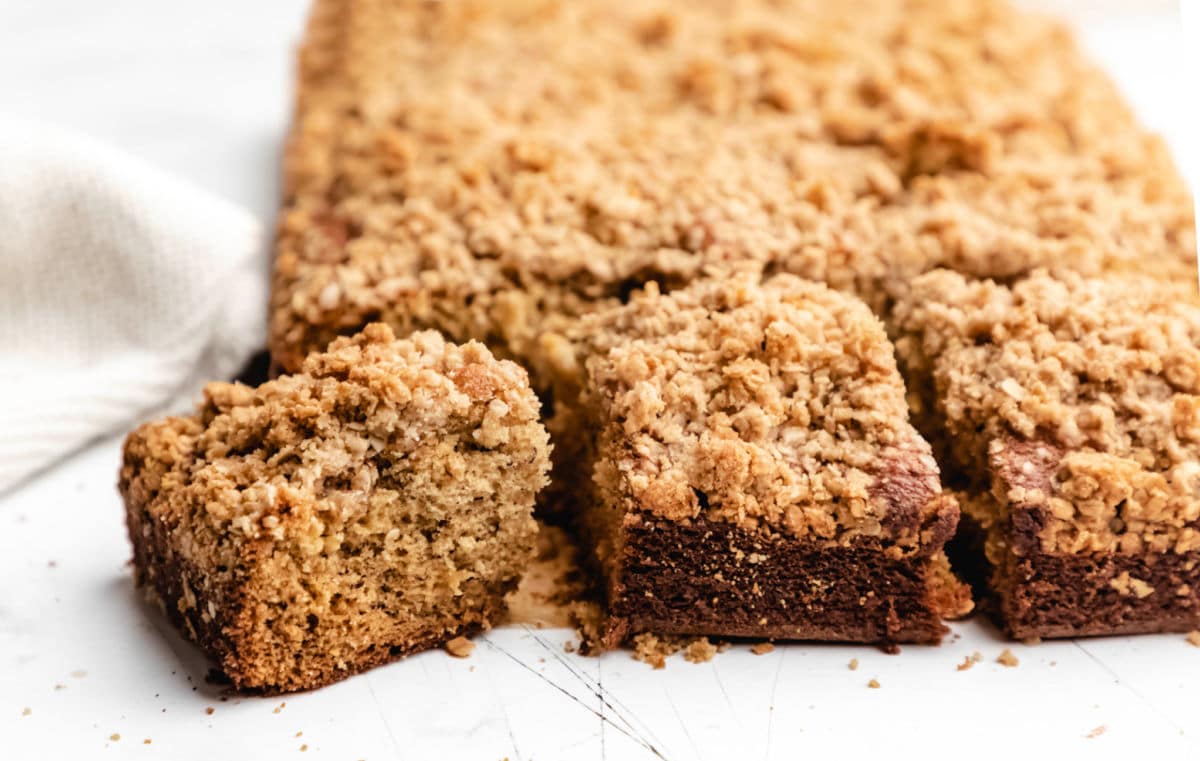 Three pieces of banana crumb cake on a piece of brown parchment paper.