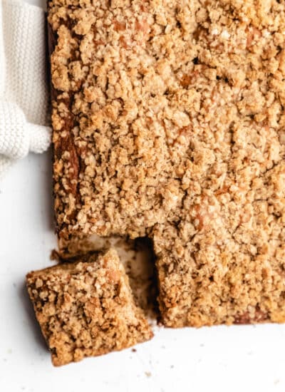 Overhead photo of a slice of banana crumb cake next to the entire cake.