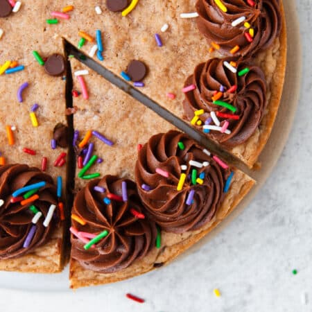 A slice of chocolate chip cookie cake cut into the cake.