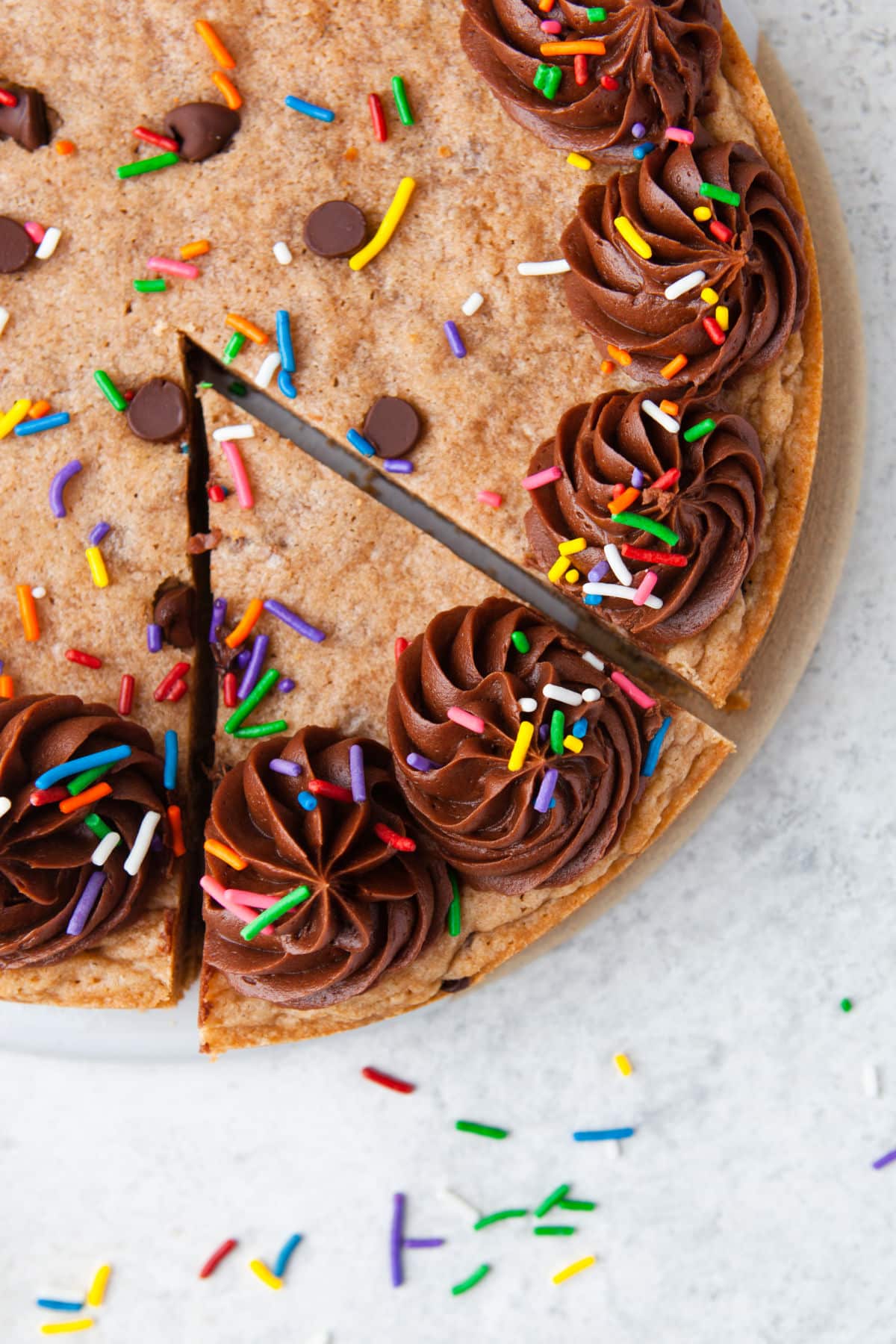 A slice of chocolate chip cookie cake cut into the cake.