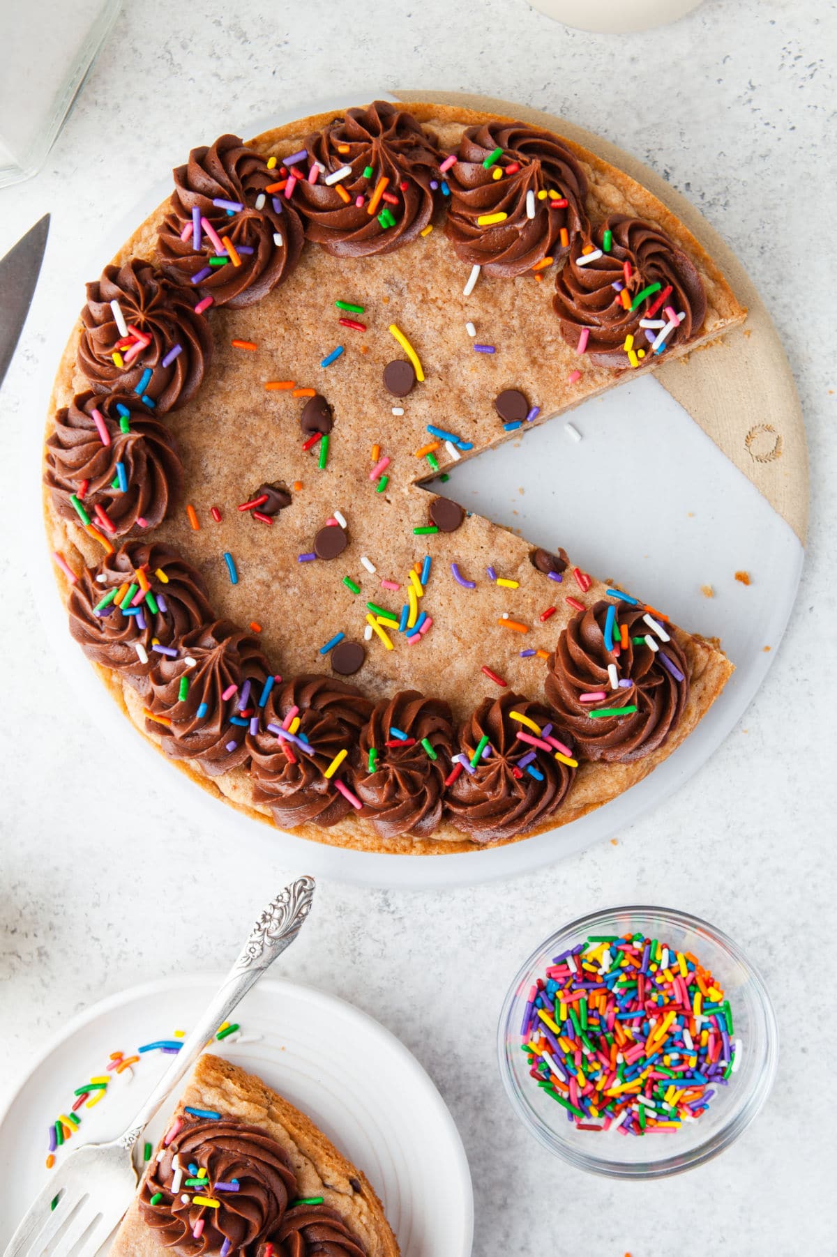 Chocolate chip cookie cake with a slice missing.