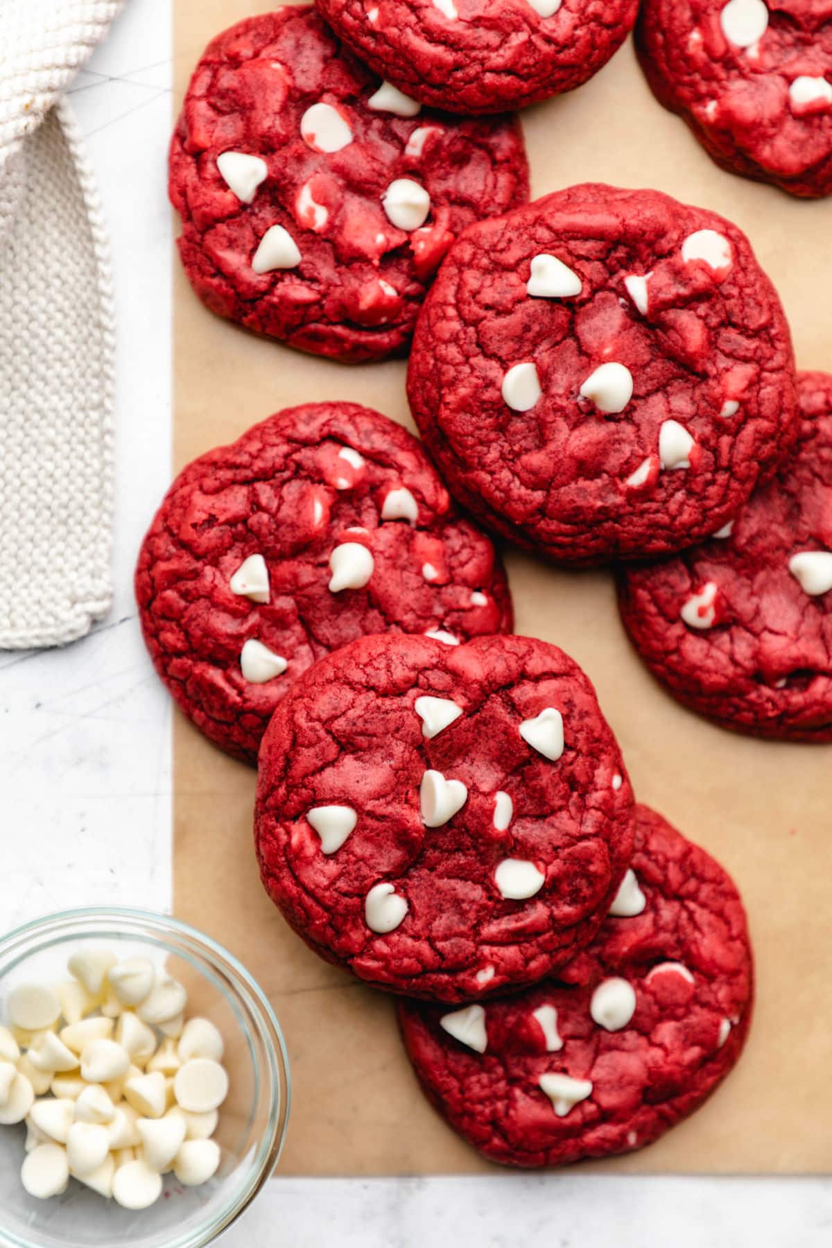 Red velvet cookies on a piece of brown parchment paper.