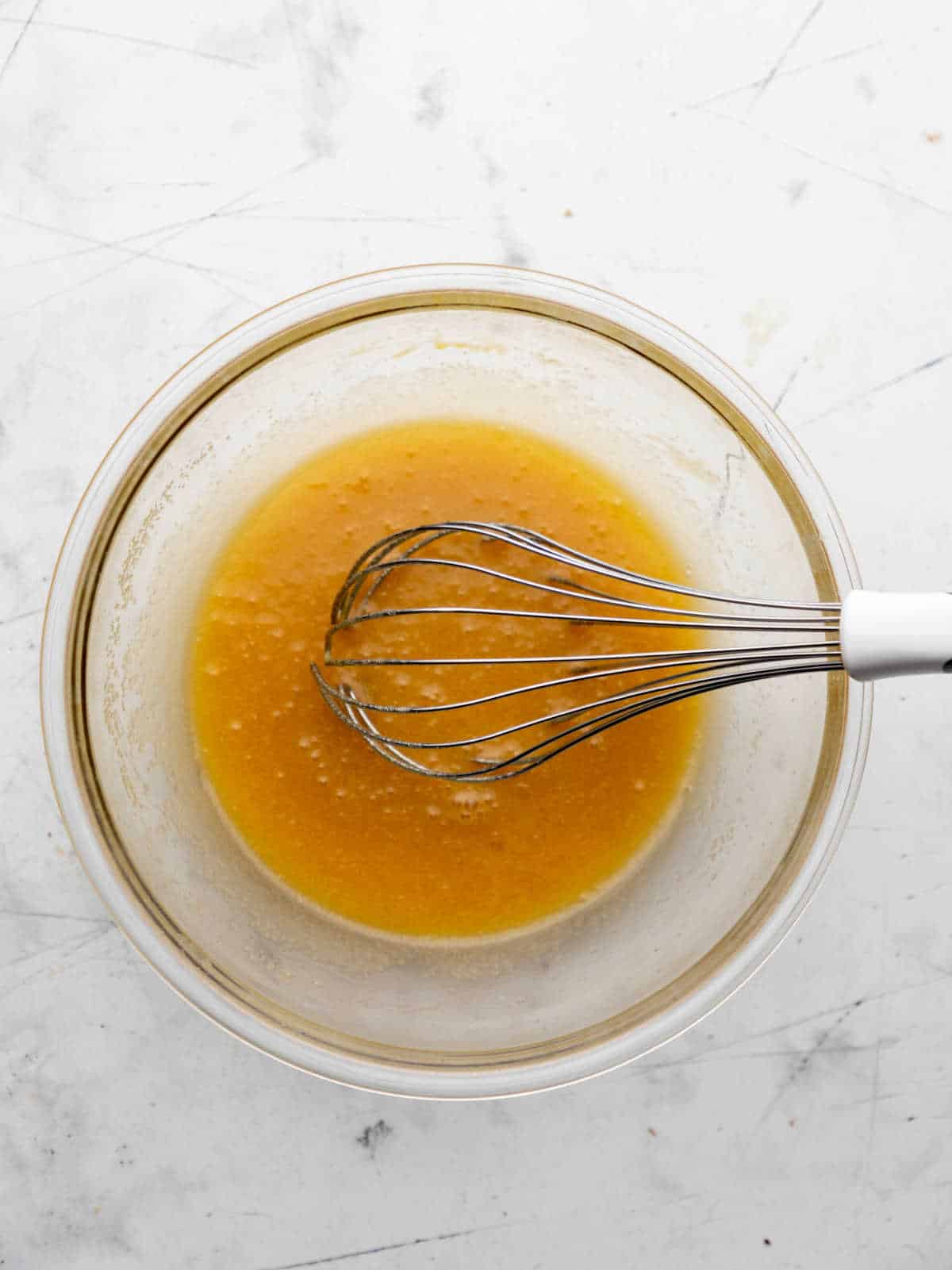 Egg whisked into melted butter and sugar.