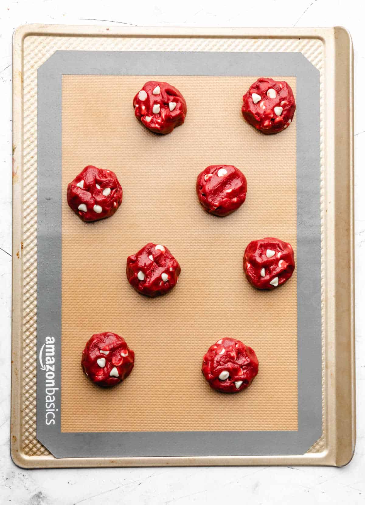 Red velvet cookie dough on a baking sheet. 