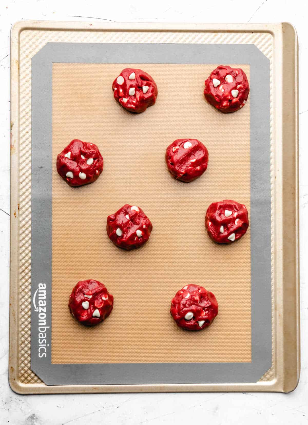 Red velvet cookie dough on a baking sheet.