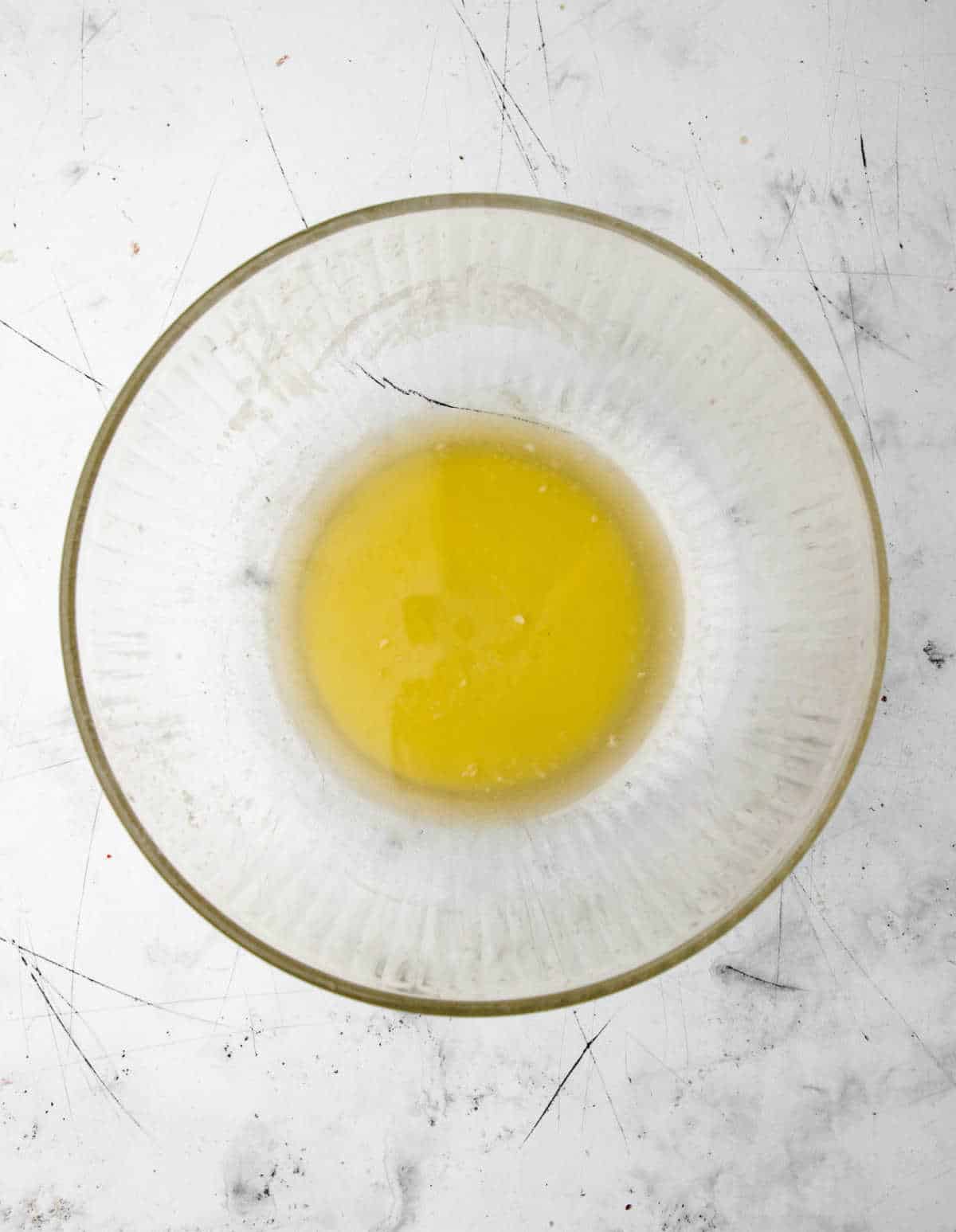 Melted butter in a glass mixing bowl.