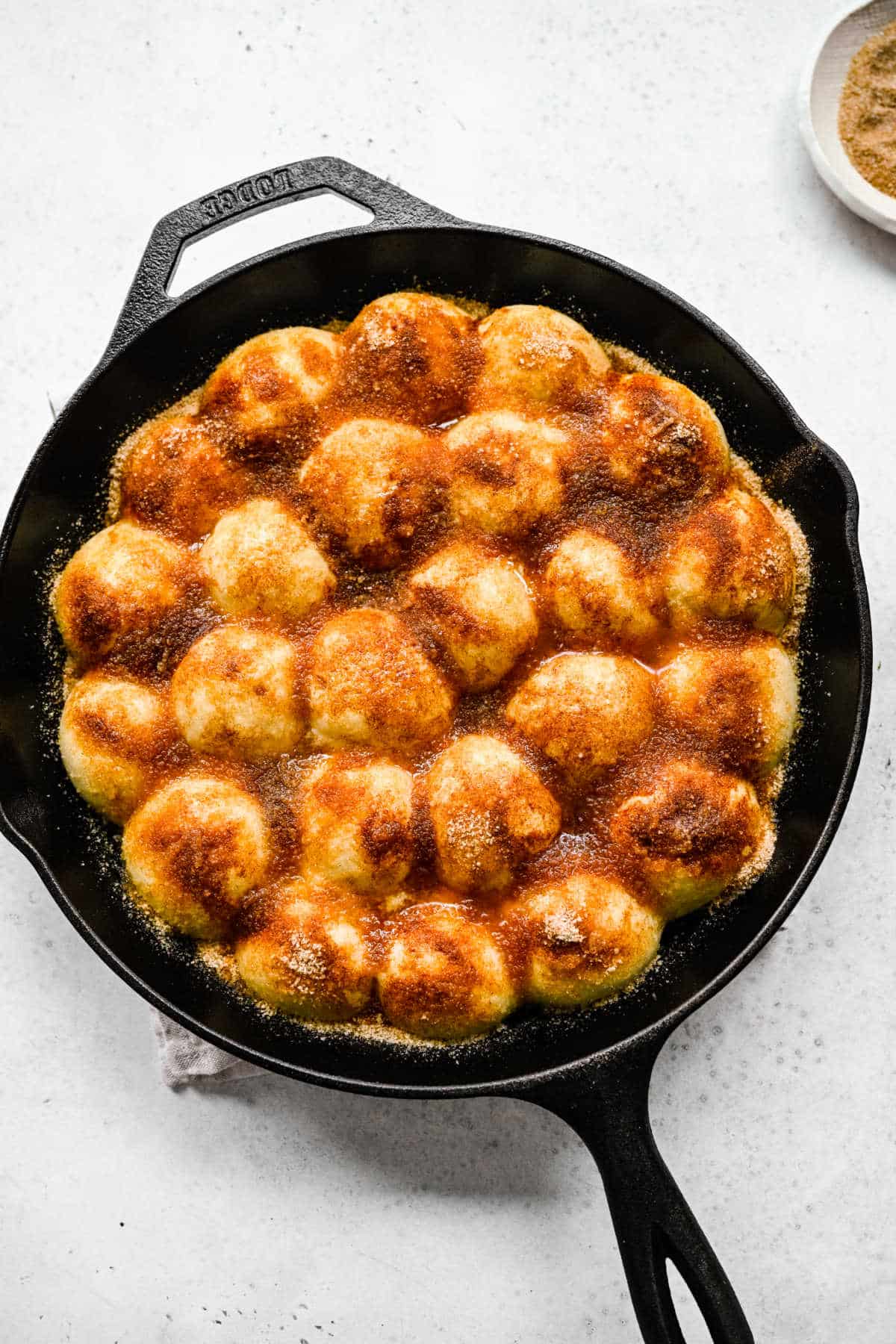 Cinnamon sugar mixture over cinnamon roll bites. 