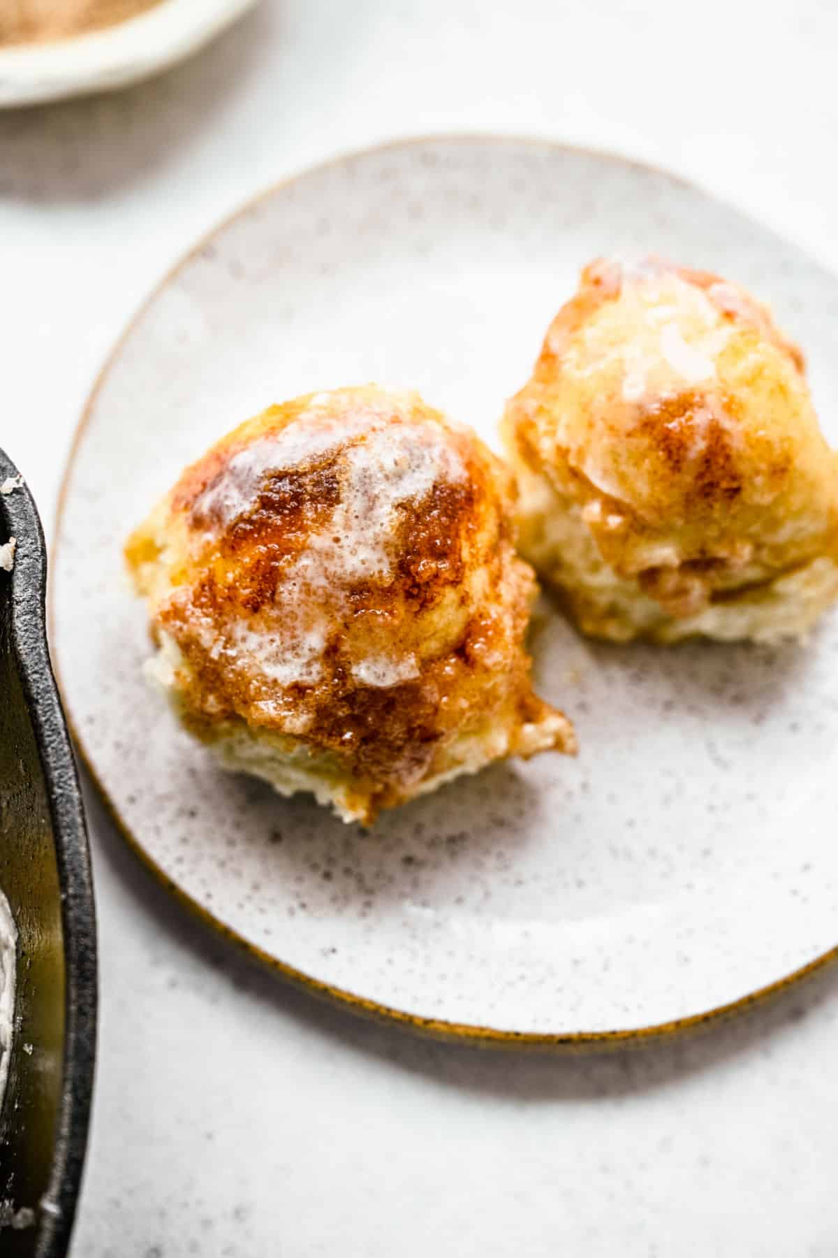 Two cinnamon roll bites on a plate. 