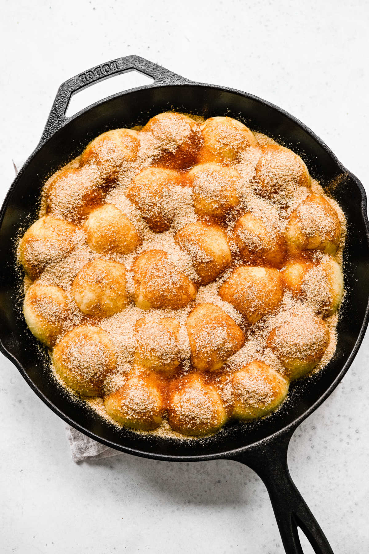 Cinnamon sugar sprinkled over butter on cinnamon roll bites. 