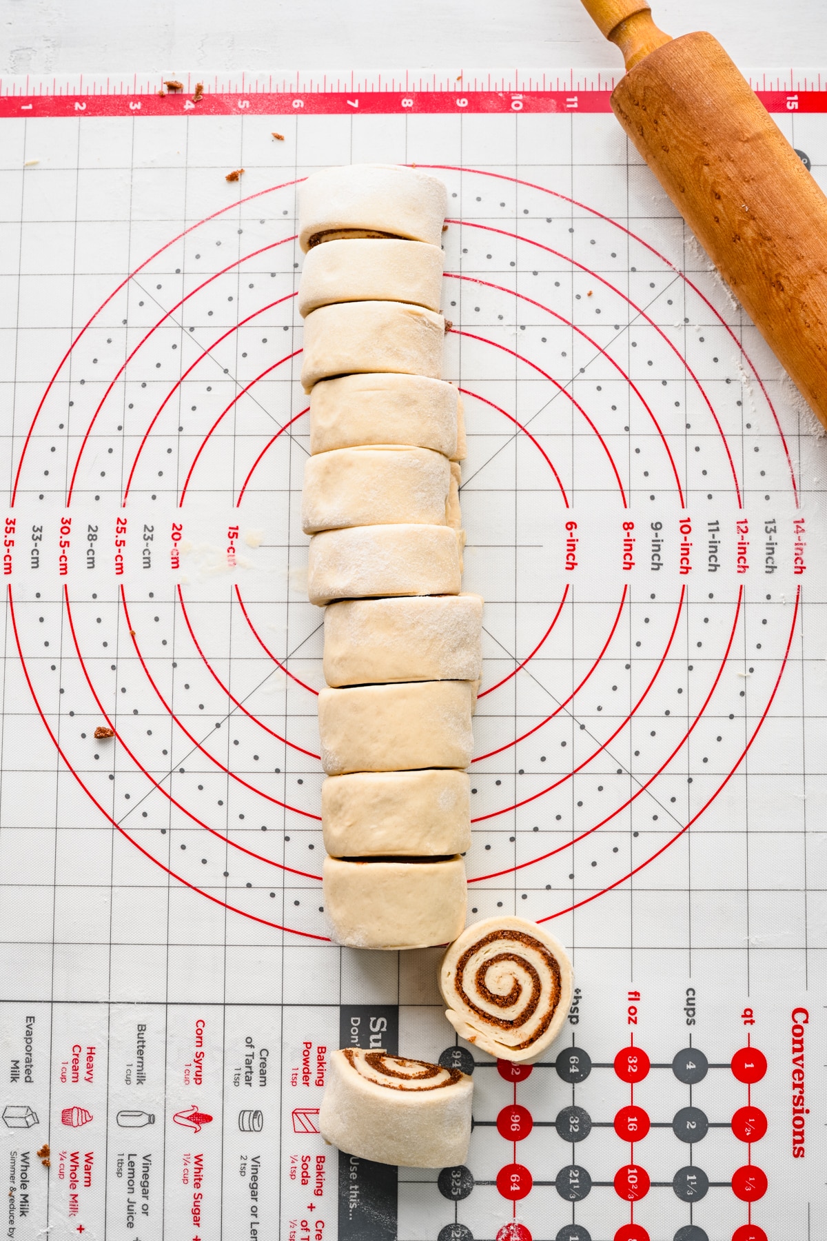 Rolled up cinnamon roll dough with two pieces cut.