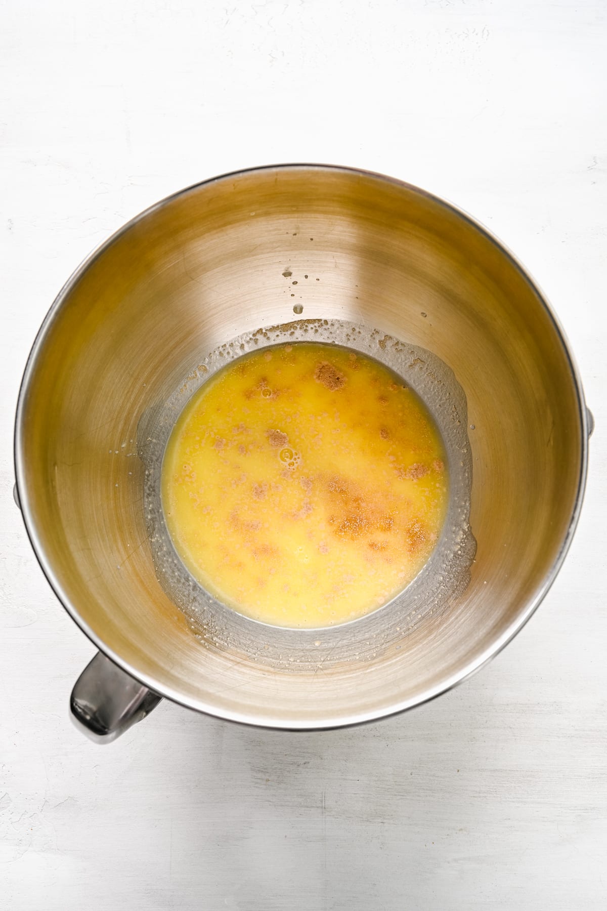 Butter mixture and yeast in a mixing bowl. 