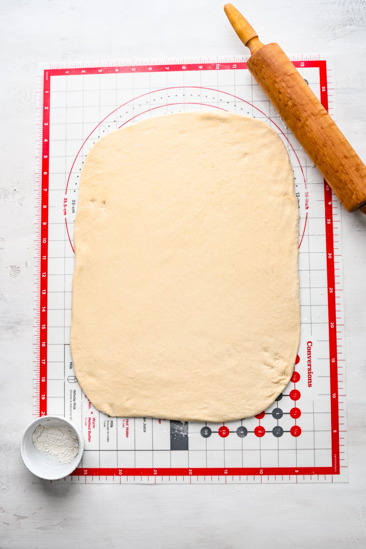 Cinnamon roll dough rolled out into a rectangle. 