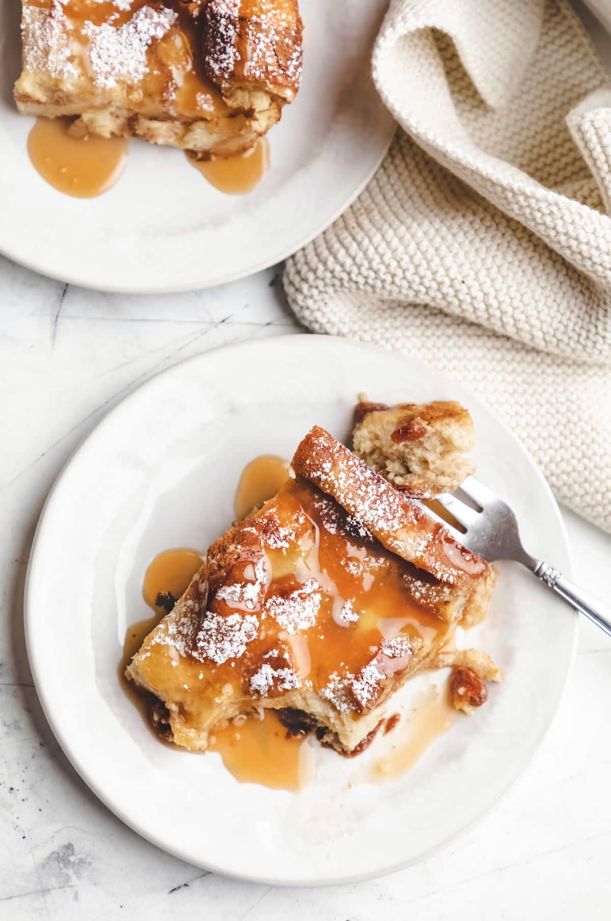 Two plates of Irish bread pudding next to a knit napkin.