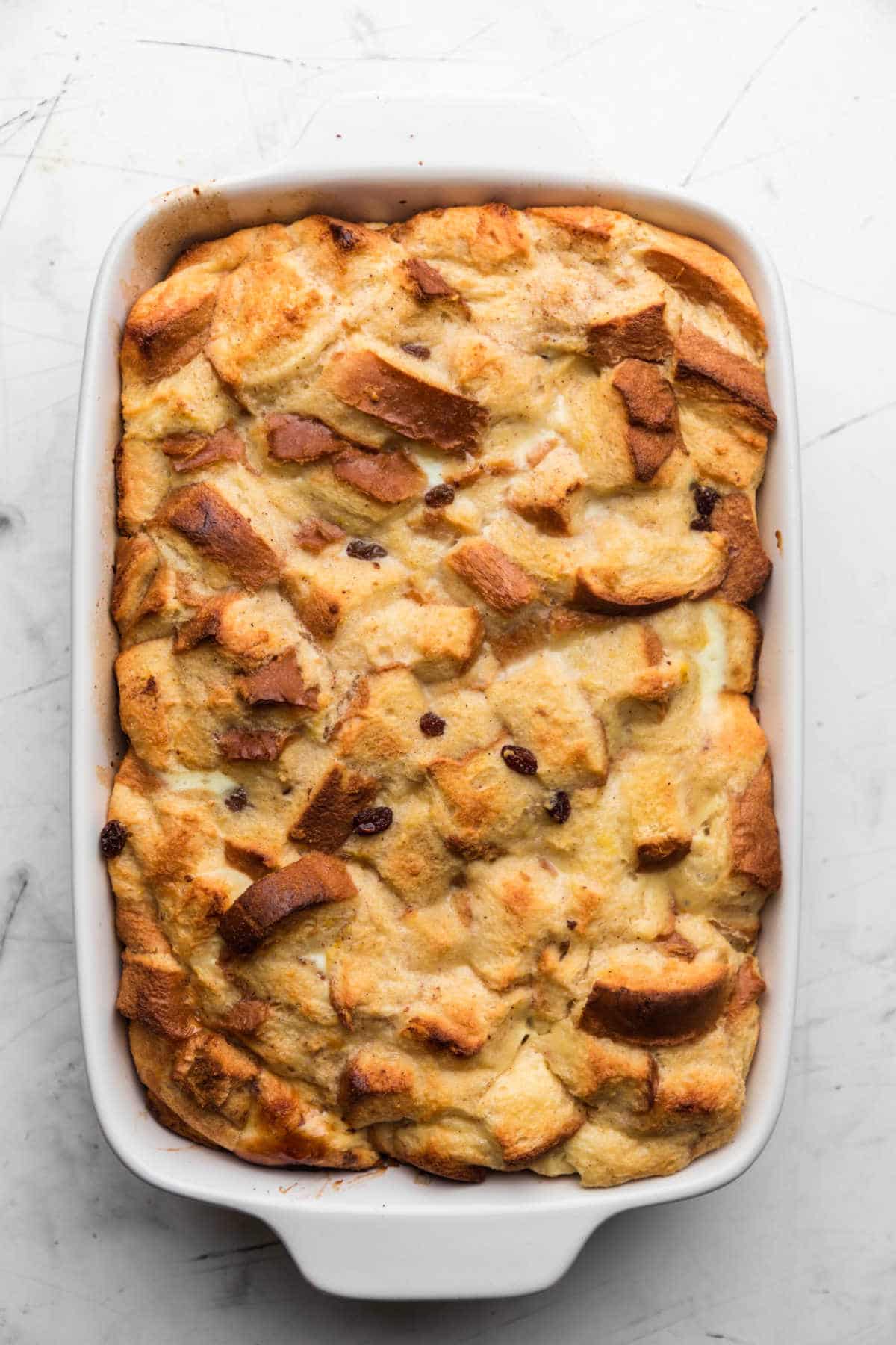 Baked Irish bread pudding in a white baking dish. 