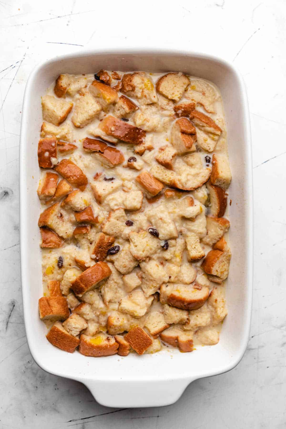 Raisins and bread cubes in egg mixture for Irish bread pudding.