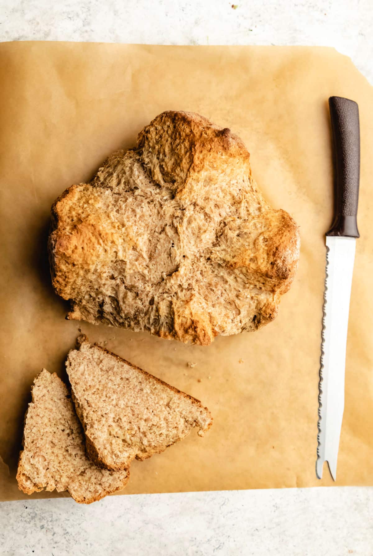 Two slices of Irish brown bread next to the loaf.