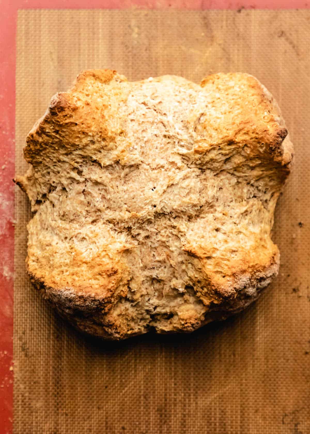 Baked Irish brown soda bread on a silicone baking mat. 