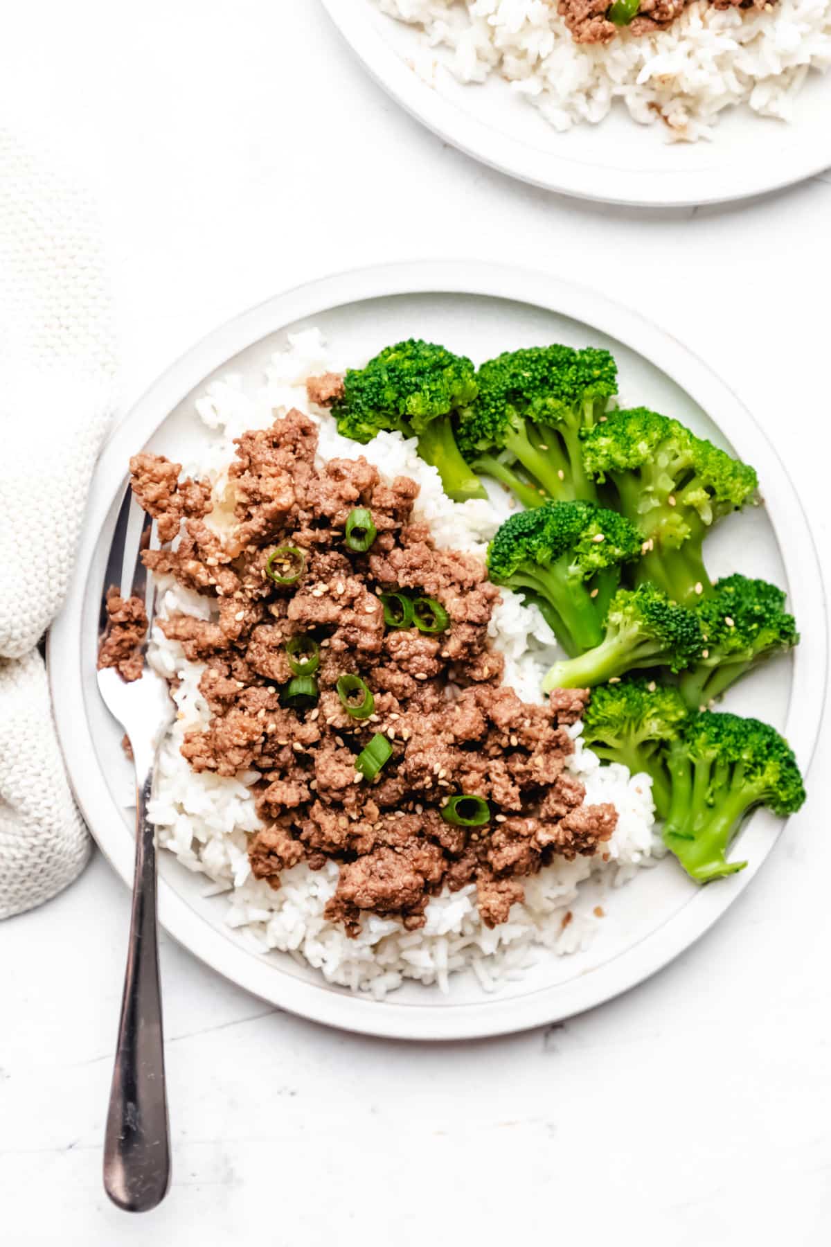 A plate of Korean ground beef and broccoli topped with sesame seeds. 