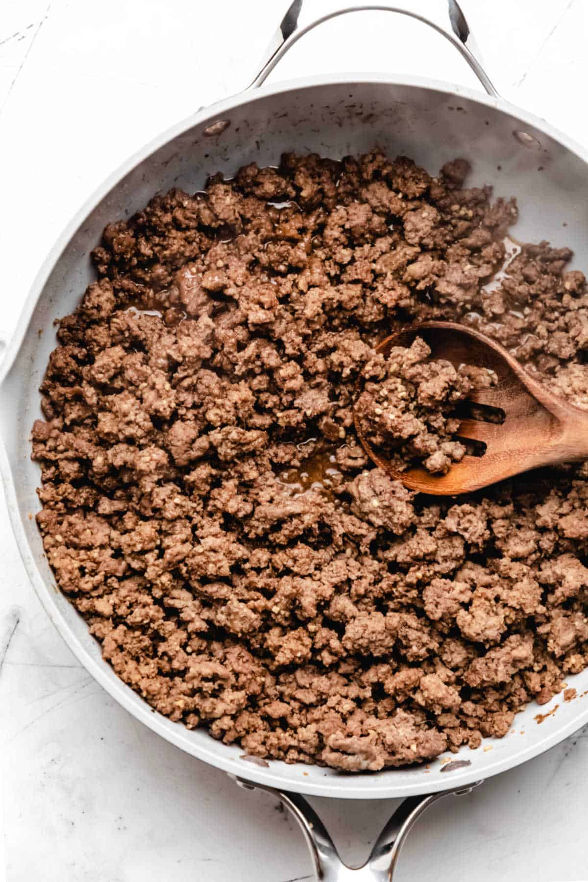 A wooden spoon scooping up Korean ground beef. 