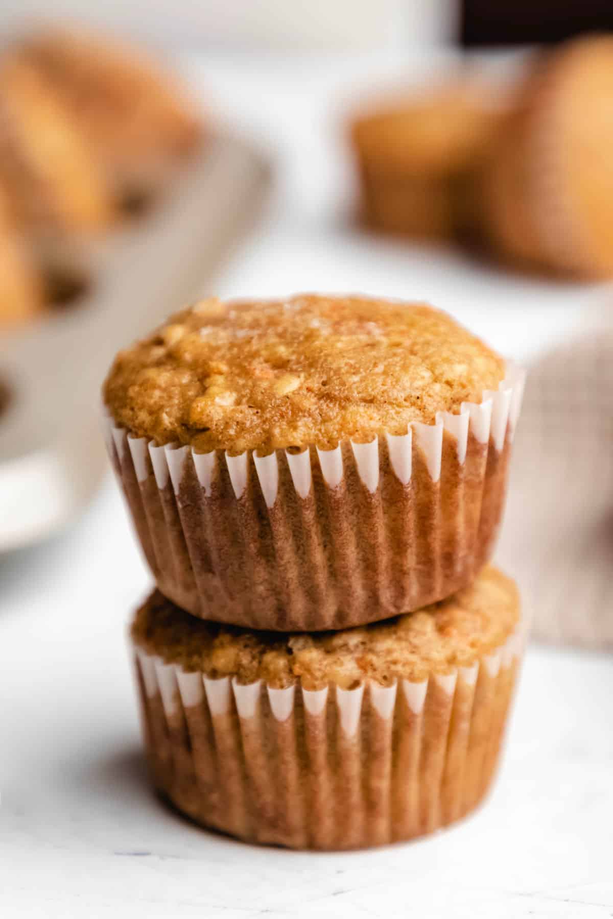 Two carrot oat muffins stacked on top of each other. 