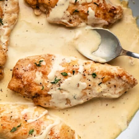 Four chicken breasts covered with creamy mustard sauce.