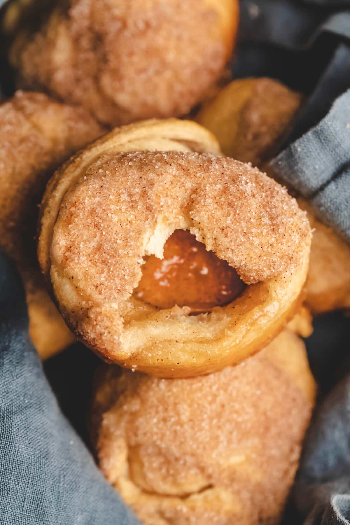 A blue linen lined bread basket full of empty tomb rolls. 