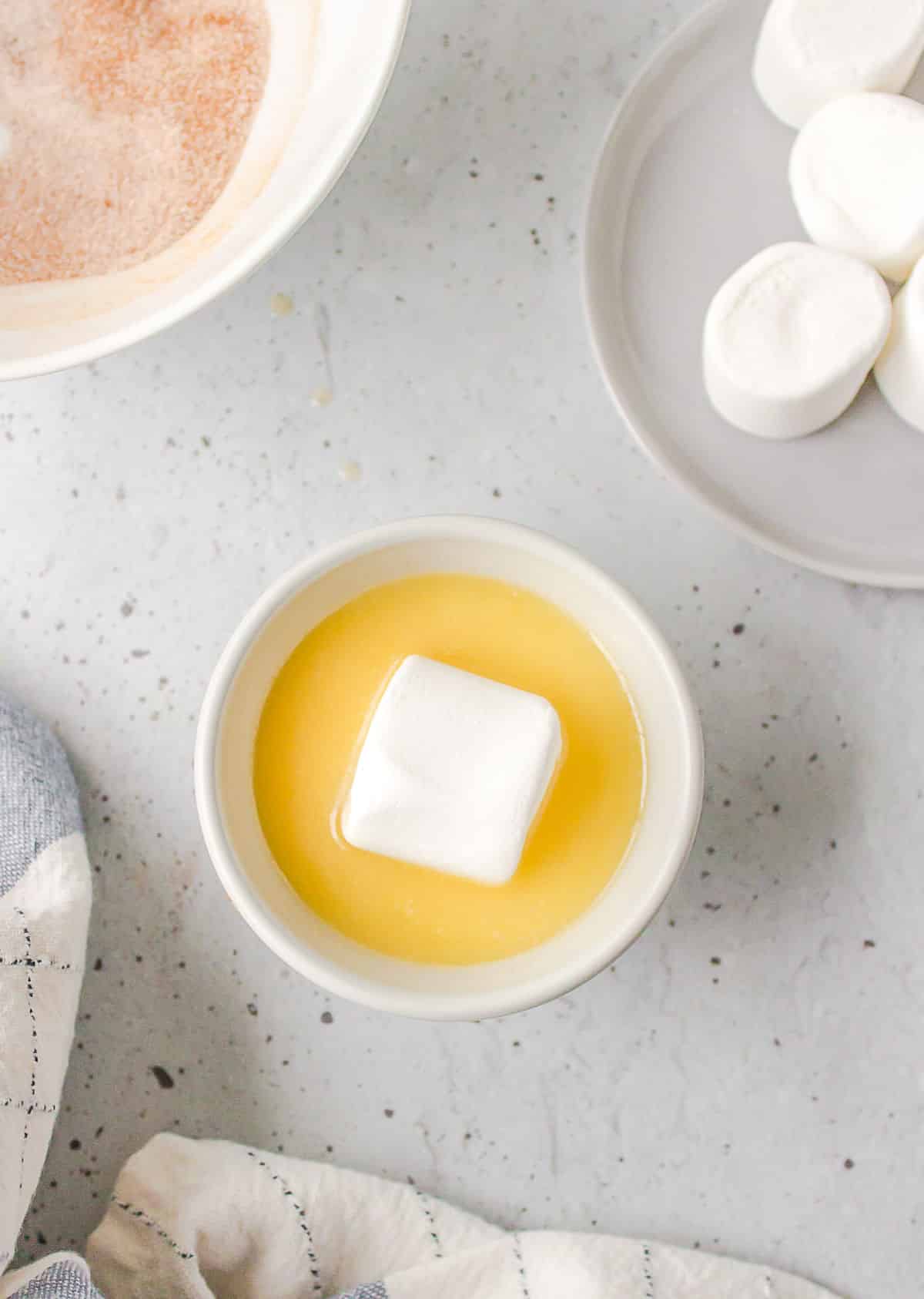 A large marshmallow in a dish of melted butter. 