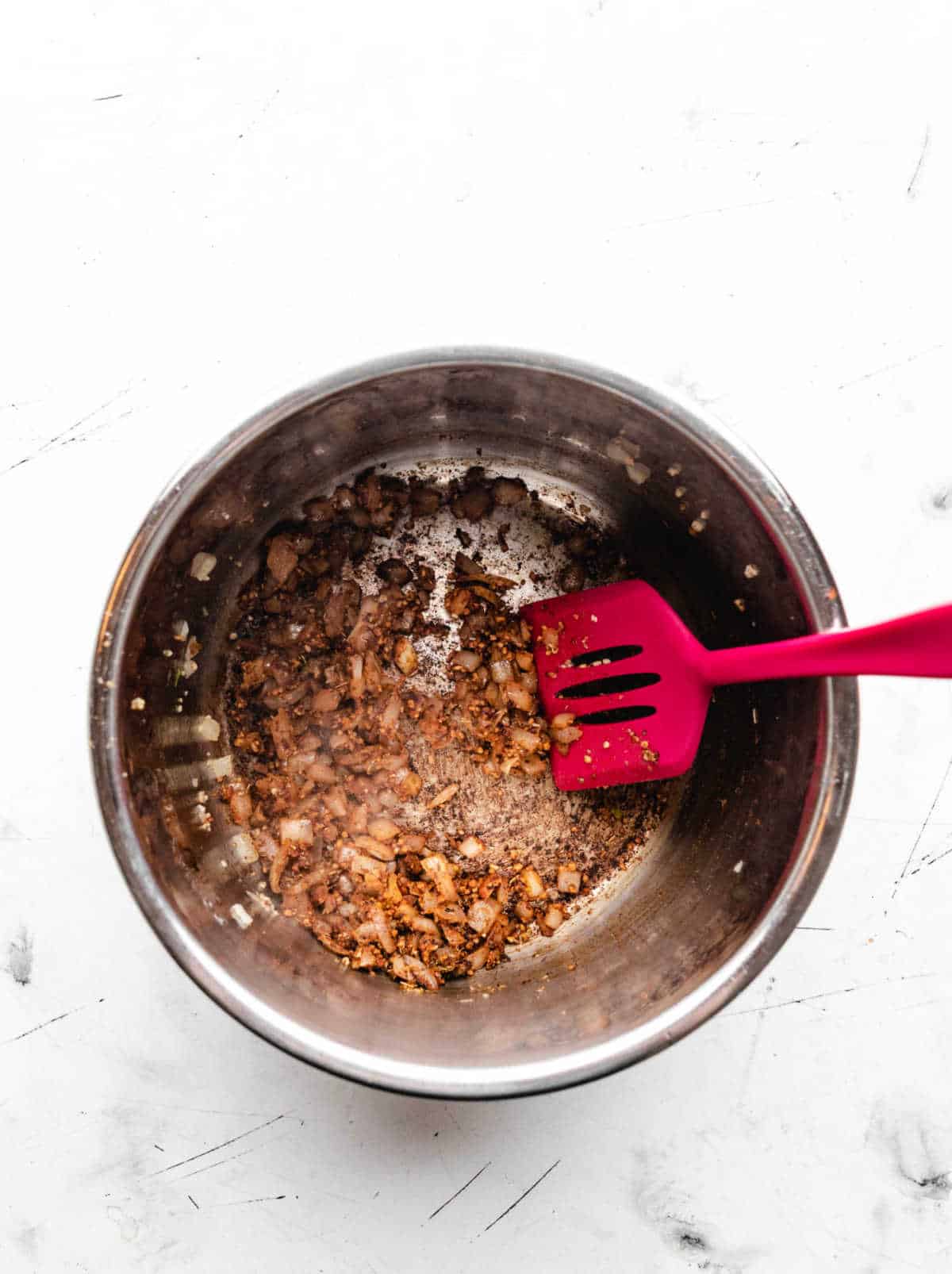 Spices stirred into sauteed garlic and onion in an instant pot.