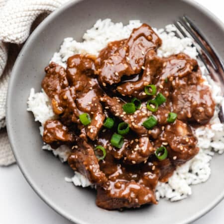 Mongolian beef and rice topped with sliced green onions.