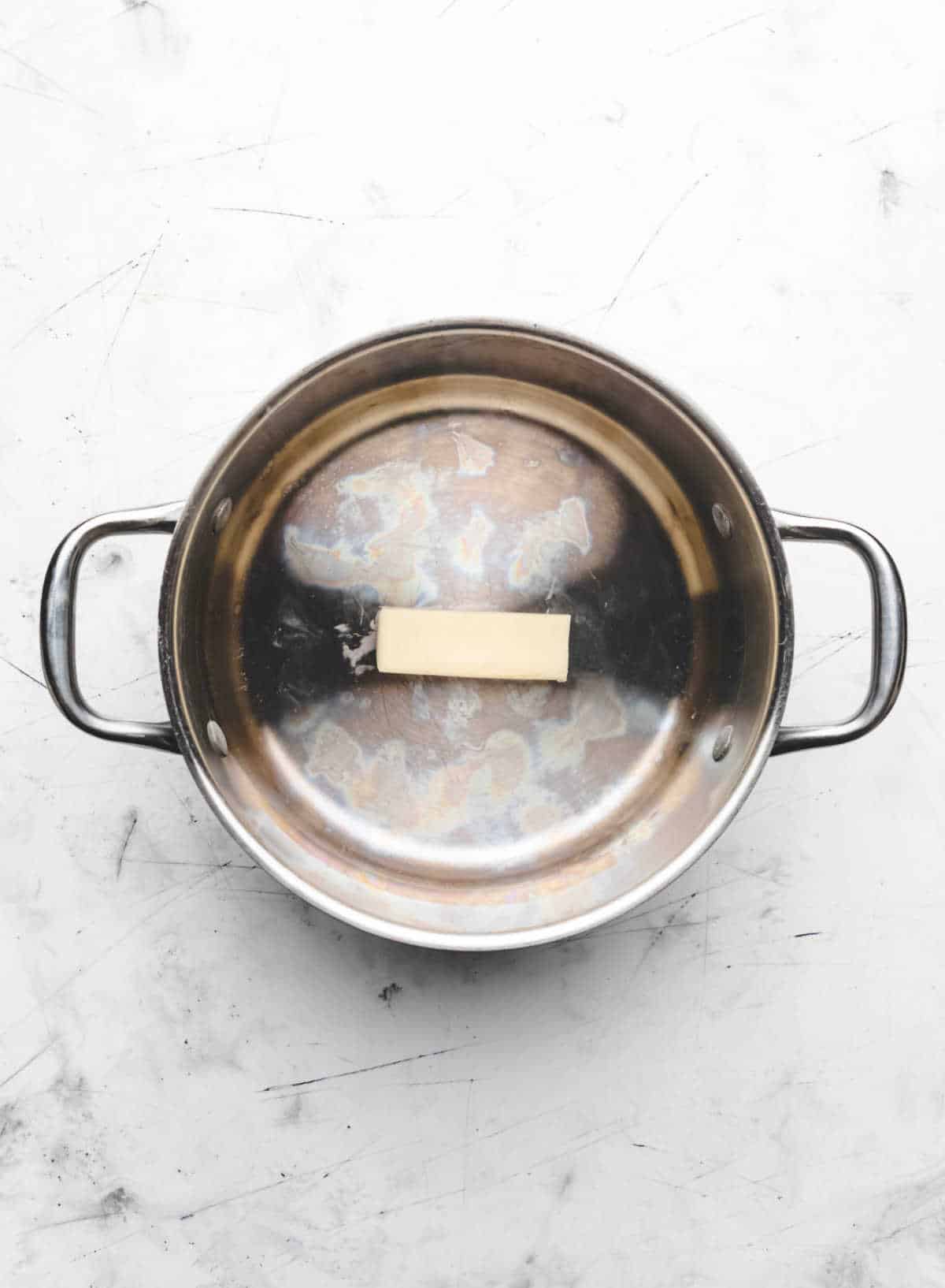 A stick of butter in a large pot. 