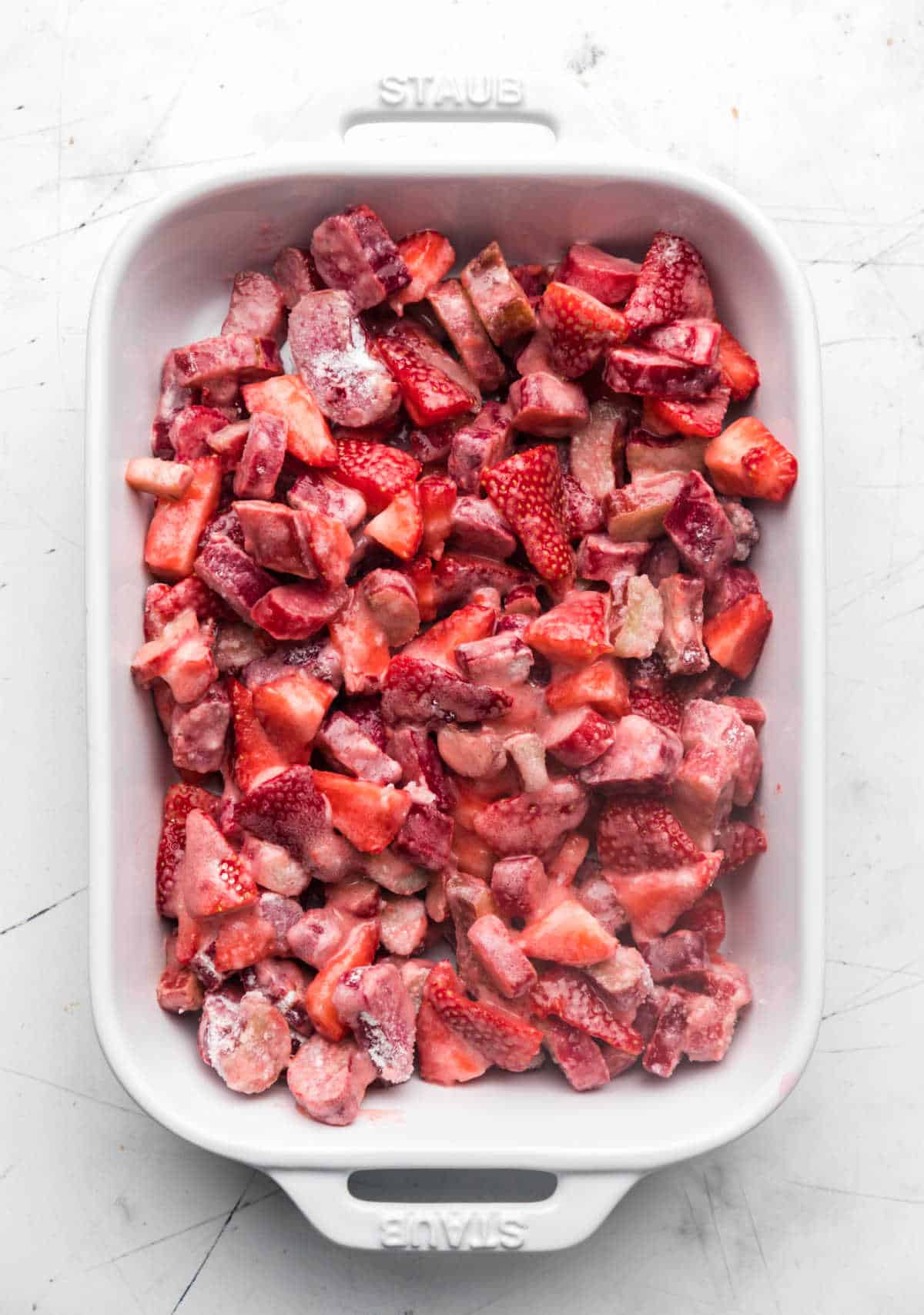 Strawberry rhubarb filling in a white baking dish. 