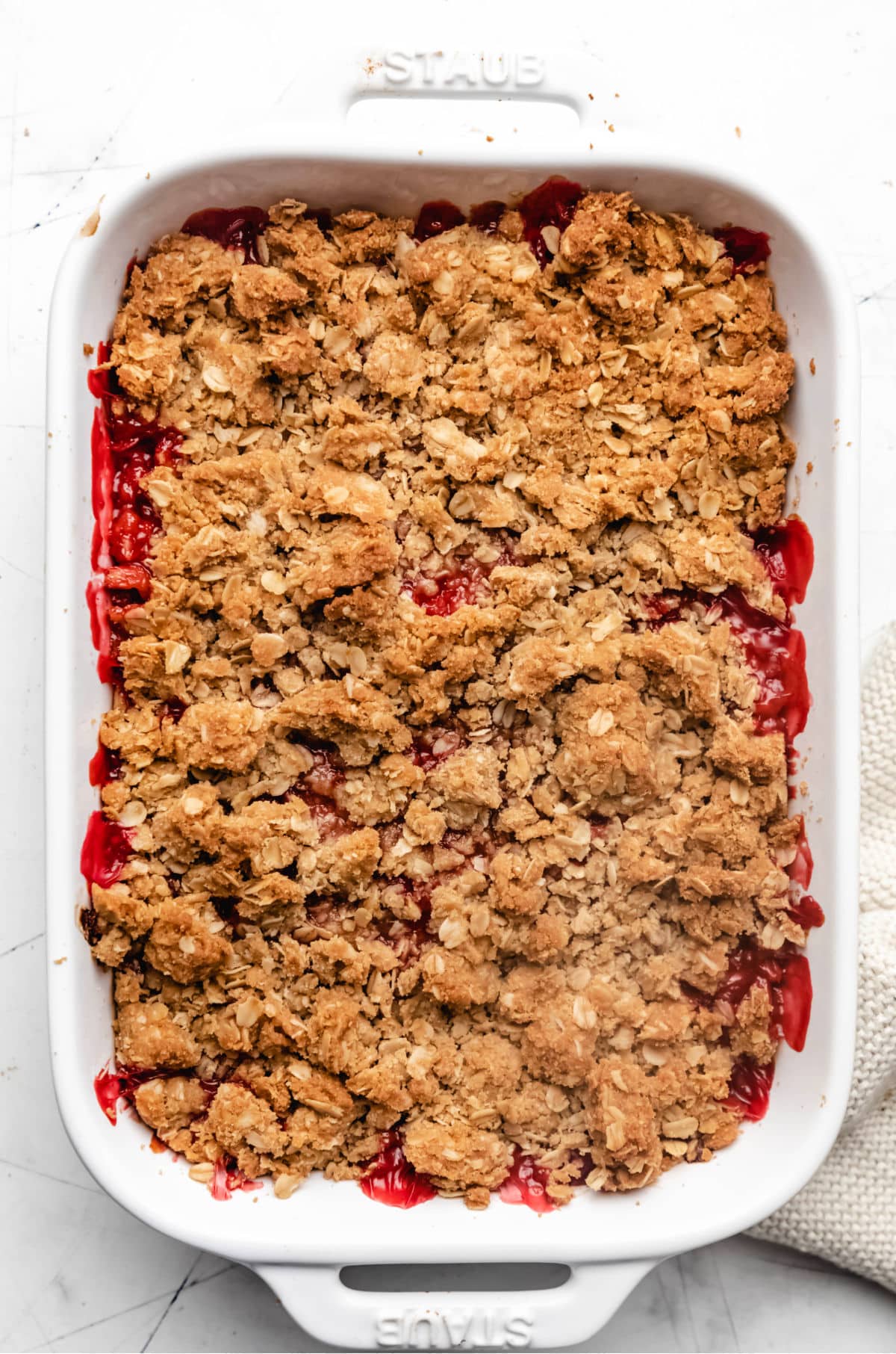 Baked strawberry rhubarb crisp in a white baking dish. 