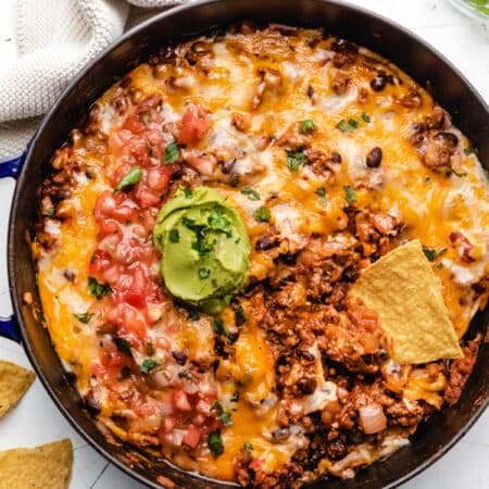 Taco casserole with a tortilla chip scooping up casserole.