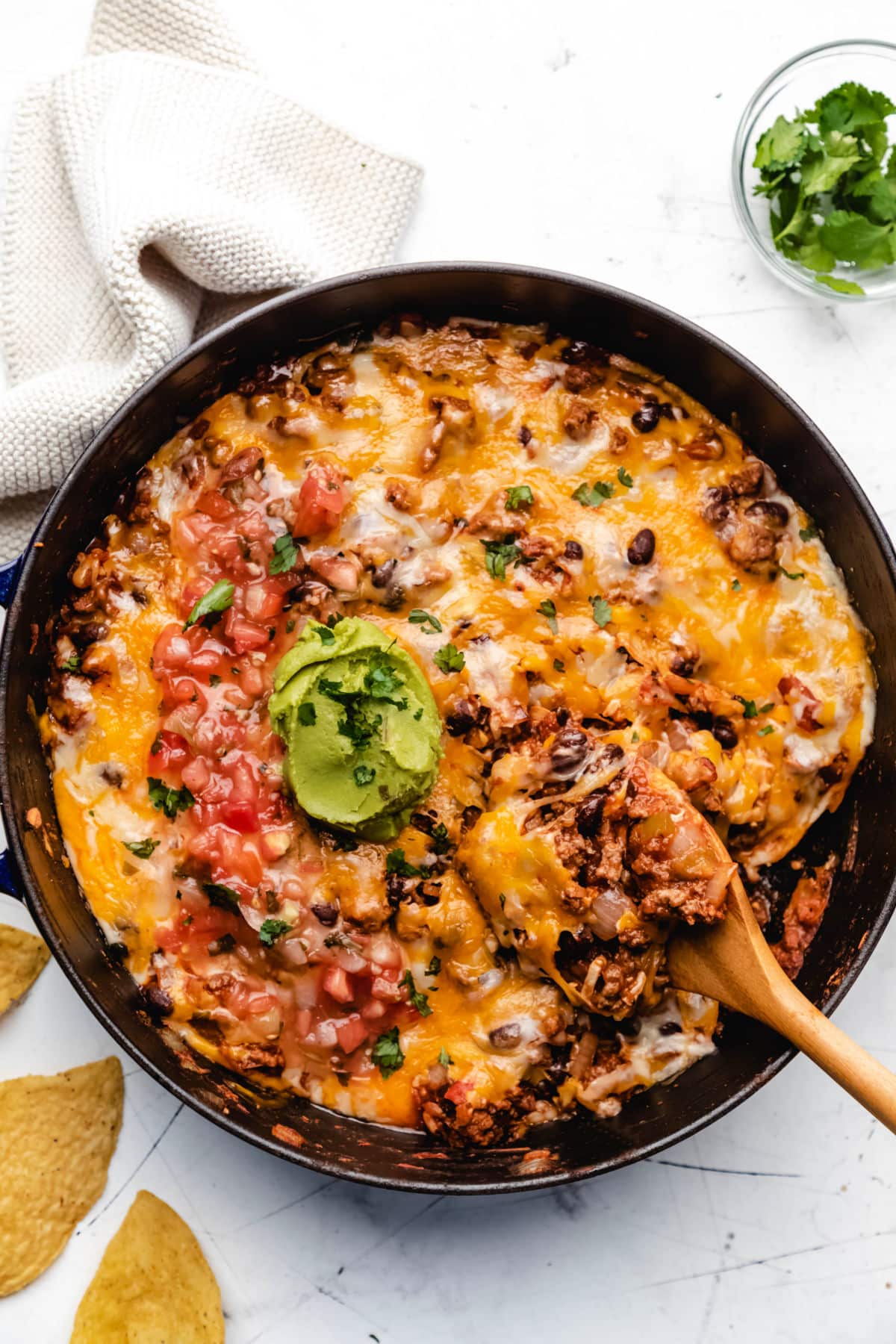 A wooden spoon scooping up taco casserole. 
