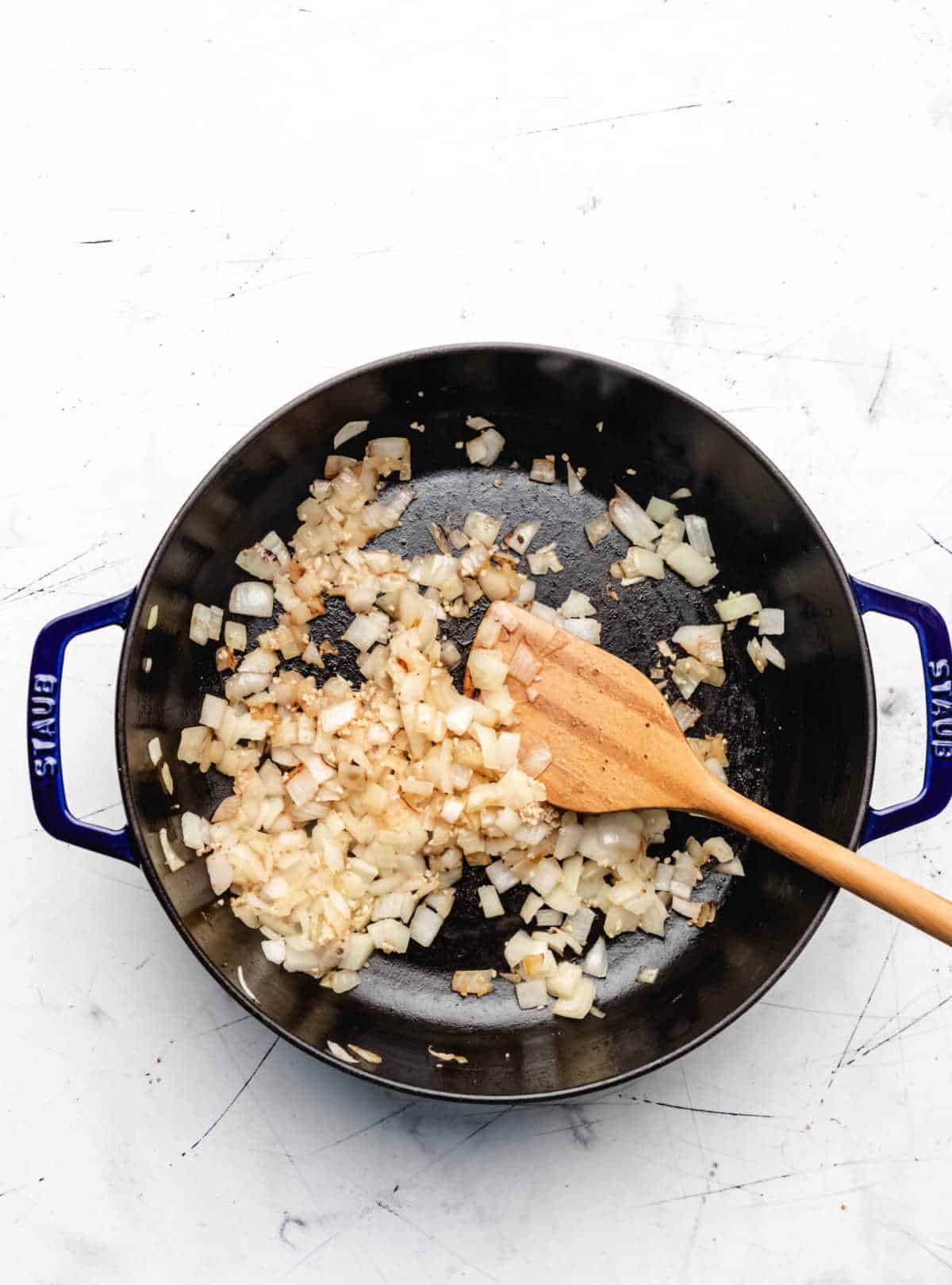 Onion and garlic cooking in a skillet. 